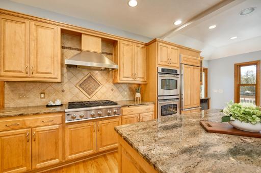 Commercial-grade appliances, custom cabinetry, granite countertops, and rich hardwood floors