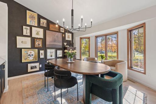 Front dining room includes butlers pantry, LVP wood floors, modern light fixture and plenty of natural light.