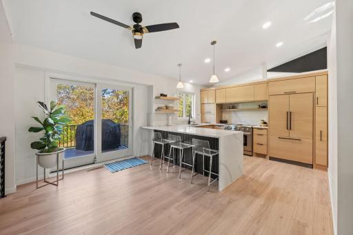 Open and airy modern kitchen, complete with waterfall quartz countertops, custom white oak cabinetry and walk out to the expansive deck.