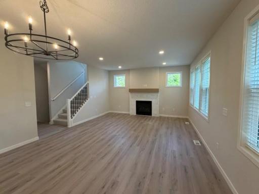 Main floor Gathering Room with elegant tiled gas fireplace, plus blinds included