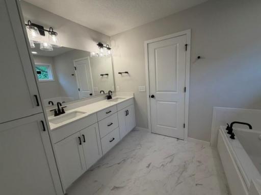 Luxurious Primary Bathroom with separate tub and tiled shower and amazing walk-in closet!