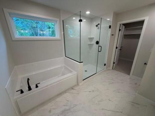 Primary Shower, separate tub, linen cabinet, and walk-in closet with shelving!