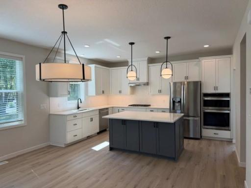 Spacious dining and gourmet kitchen with wall ovens large island and gas cooktop with pot and pan drawers! Custom Cabinets with soft-close drawers & doors.