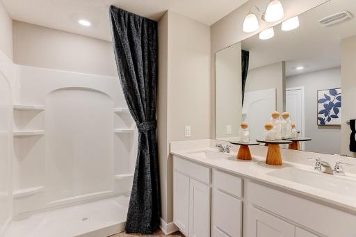 A peak into the primary bath, which features a Quartz coated double-vanity - making getting ready on those hectic mornings that much easier - and oversized stand-in shower! (Photo of model, colors are similar)