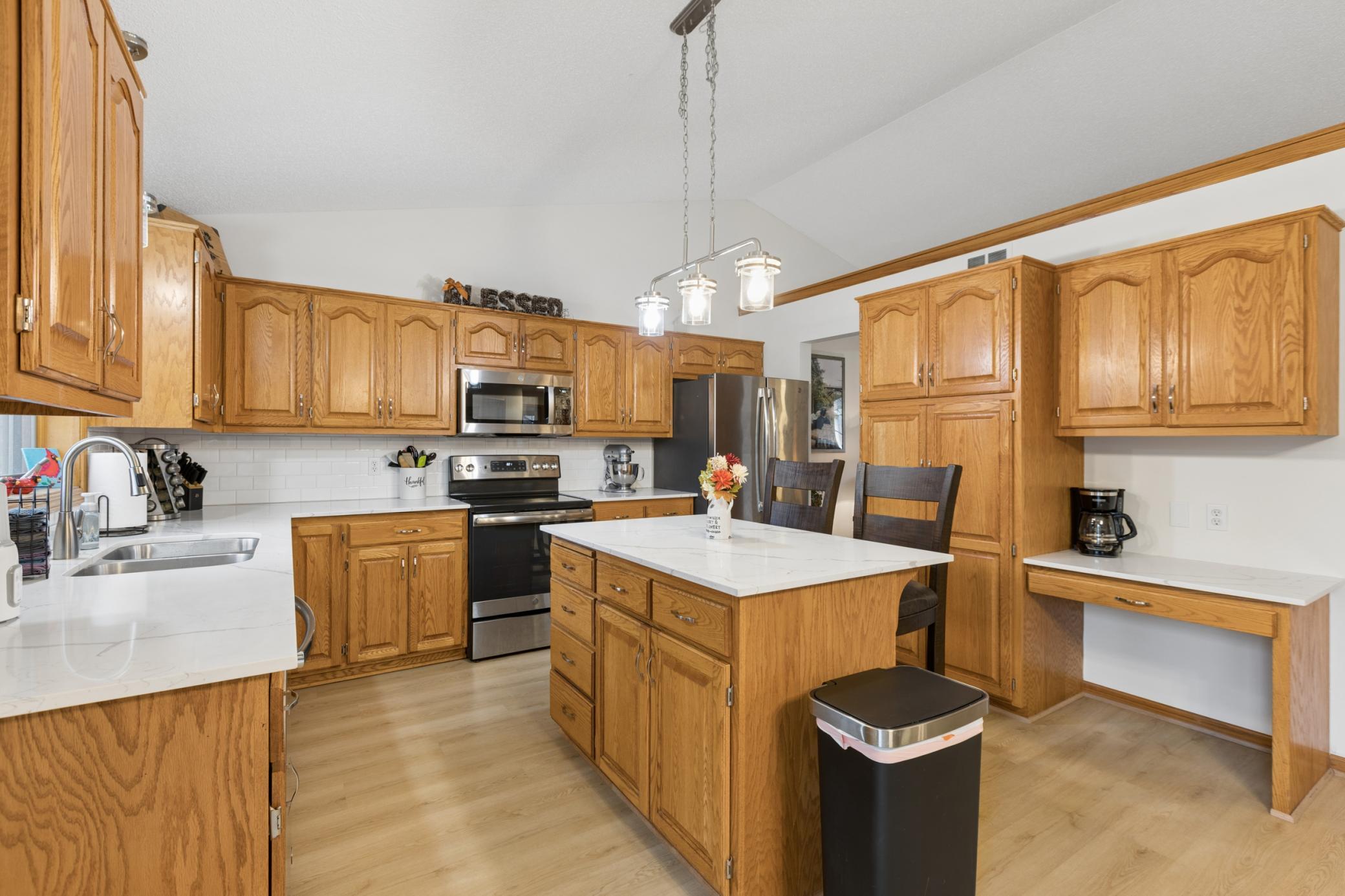 Updated kitchen with quartz countertops, stainless steel appliances, and center island
