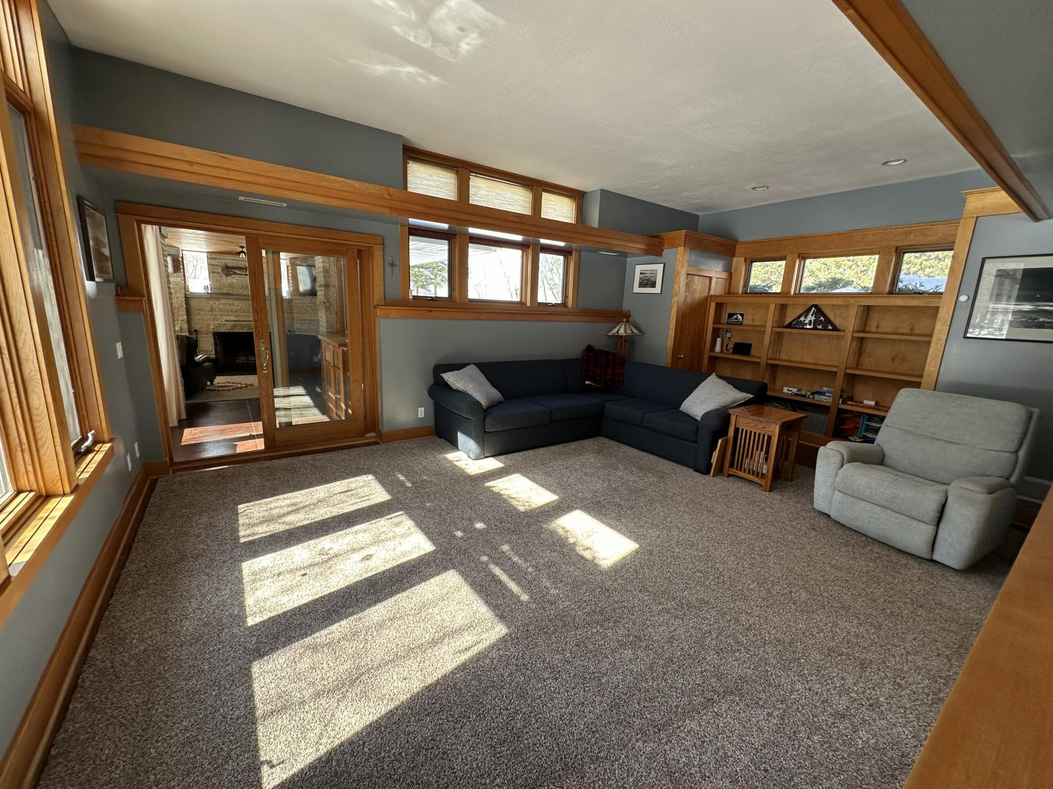 Main floor living room with oversized windows and built in shelving.