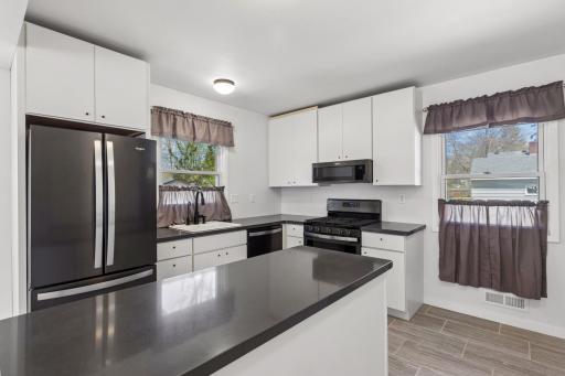 Beautiful quartz countertops, tile flooring, center island, Whirlpool appliances with smudge-proof finish, and tons of cabinet/storage space.
