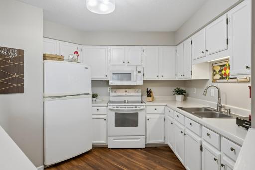 The kitchen features white cabinetry with ample counter and cabinet space