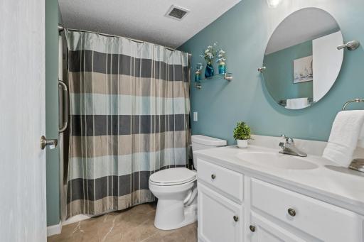 Hallway, full bath with white cabinetry and LVT flooring