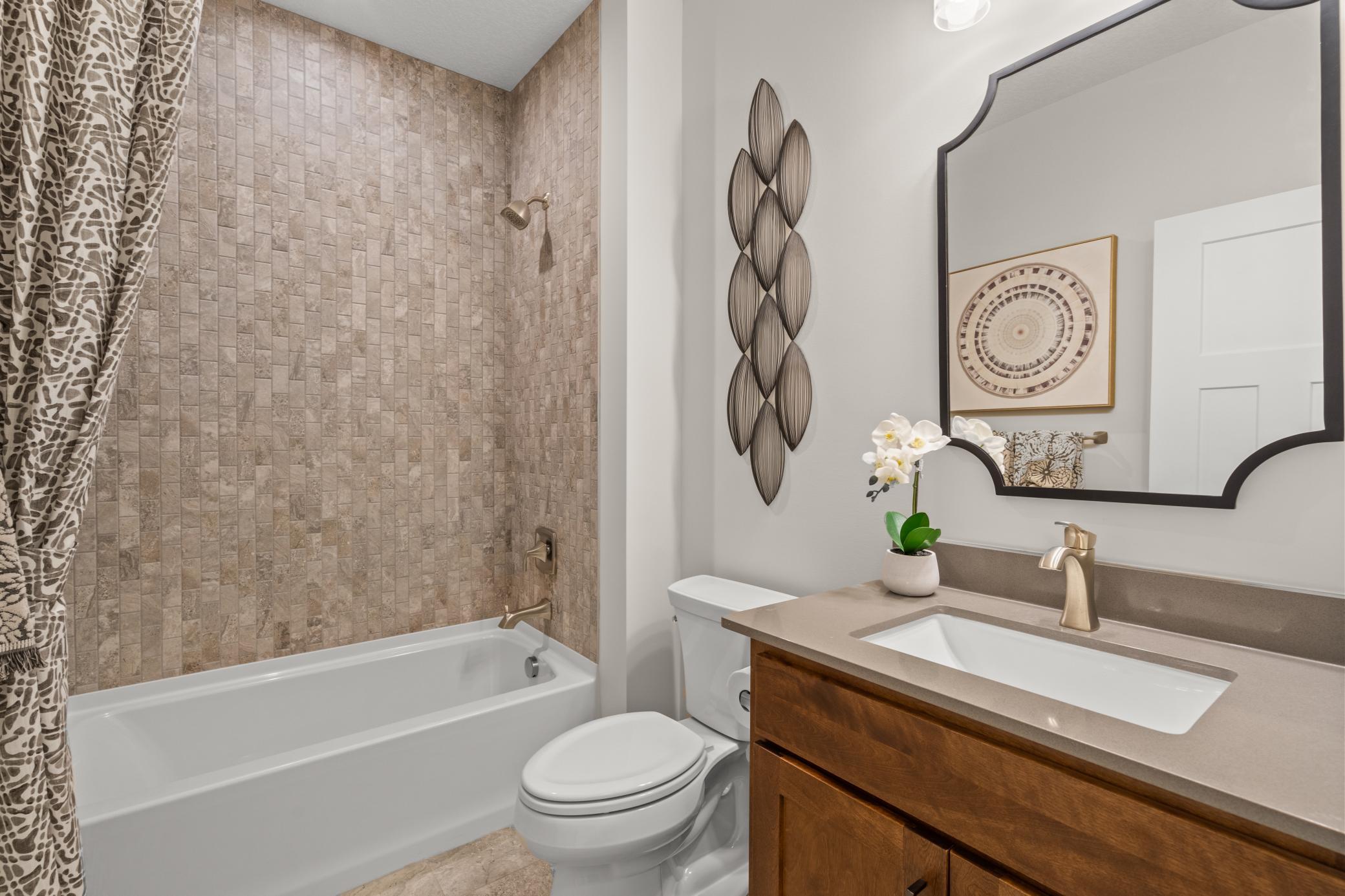 The main floor full bath works perfectly for servicing the main floor or as a bathroom for a guest to utilize. (model photo)
