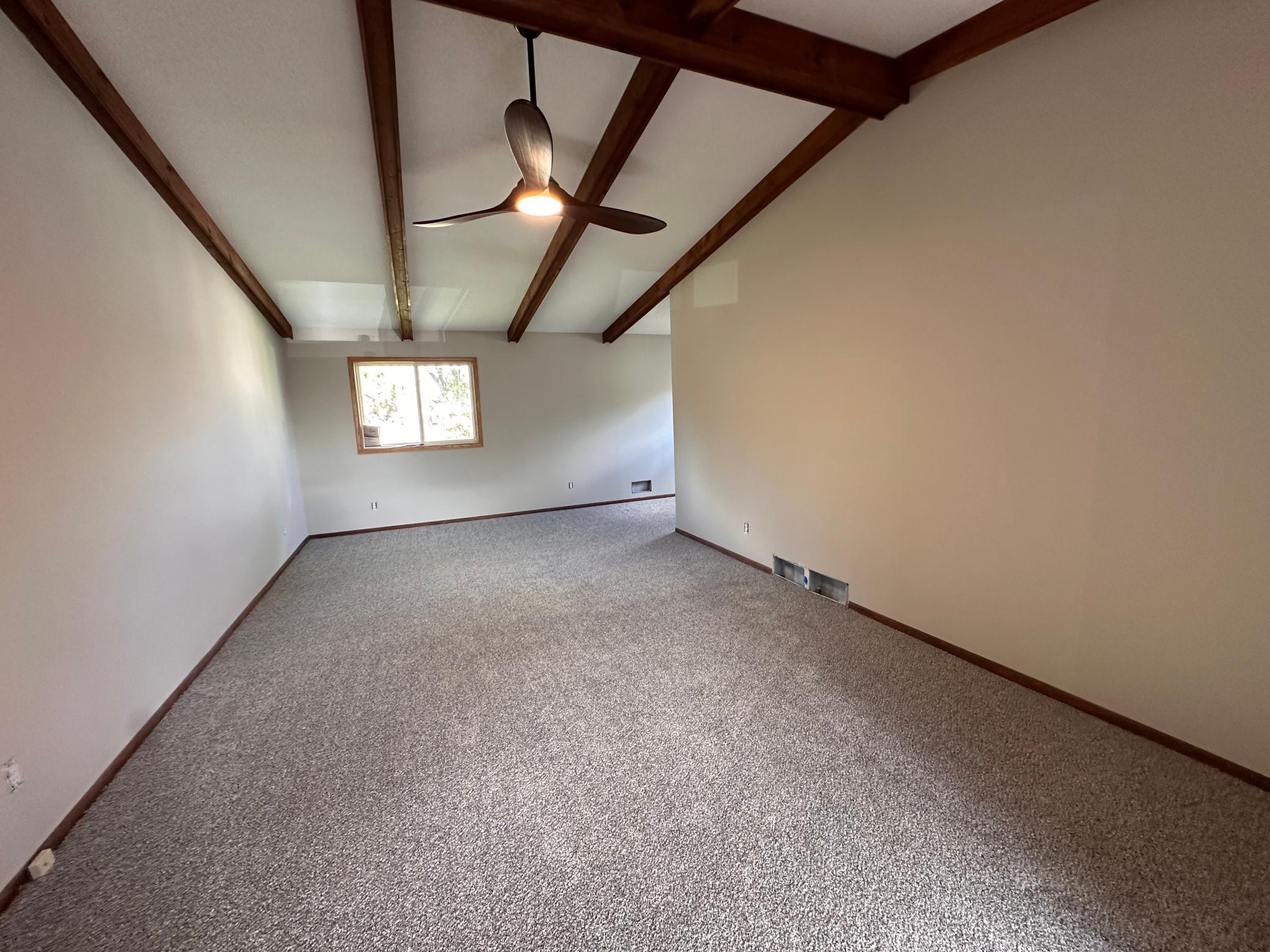 Primary massive bedroom with exposed beams