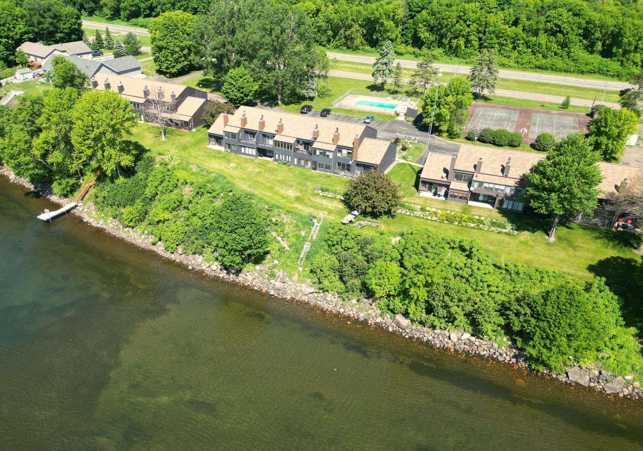 Lake view of all buildings, the pool, and tennis courts.