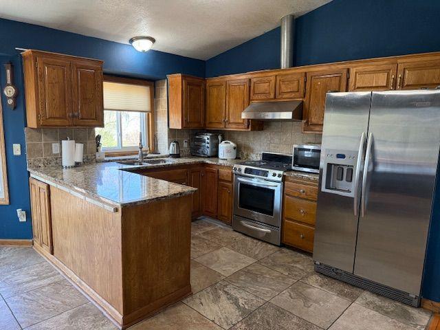 Stone countertops, ceramic tile back splash, and Stainless-Steel Appliances