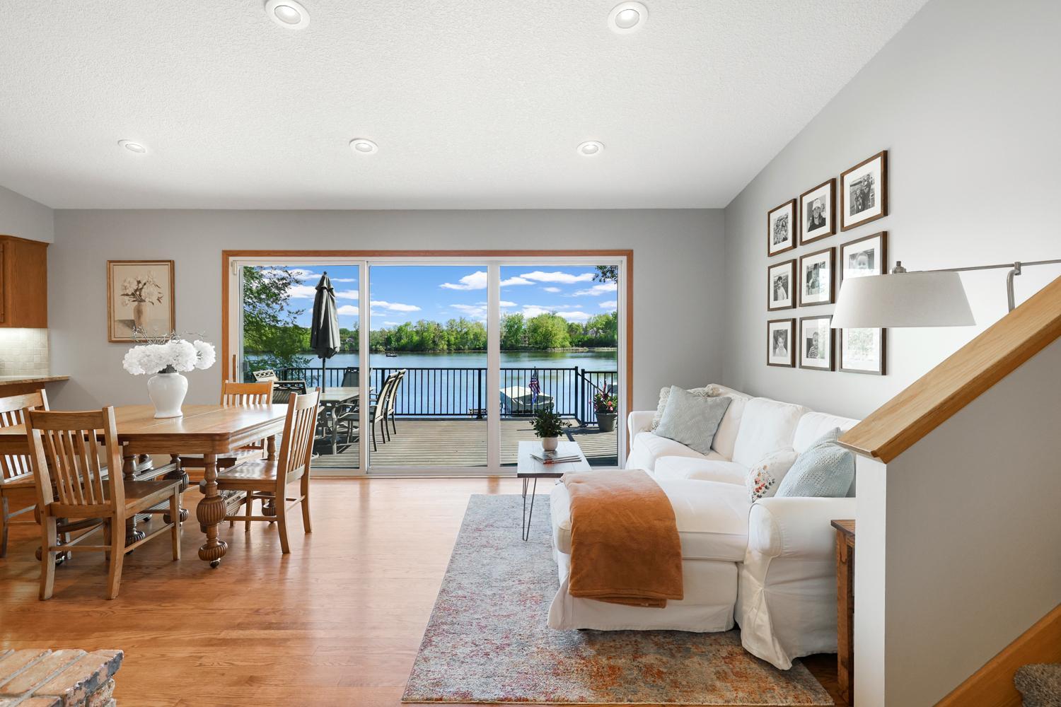 Stunning lakeside dining space with panoramic water views, expansive deck access