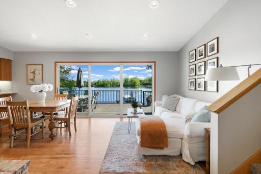 Stunning lakeside dining space with panoramic water views, expansive deck access