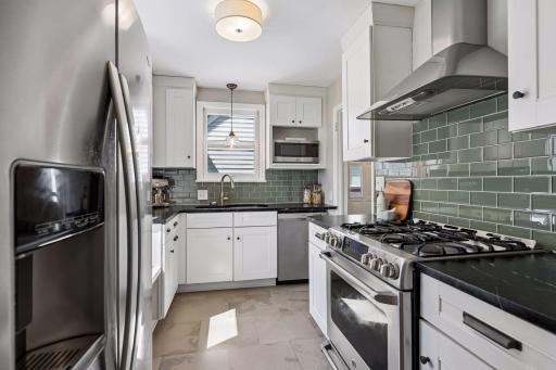 This kitchen also offers a glass washing station on the sink, pull-out trash, and tile floors.