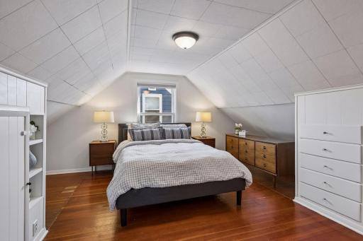 Primary bedroom on upper level. Original pine floors, new lighting, abundance of built-in drawers and closets~