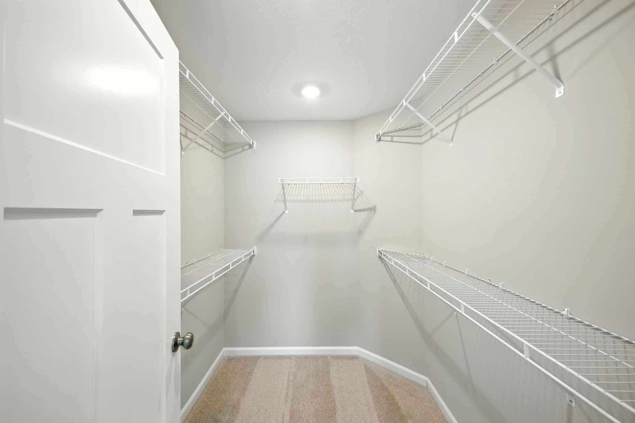 Huge walk-in closet in primary bedroom representational photo.