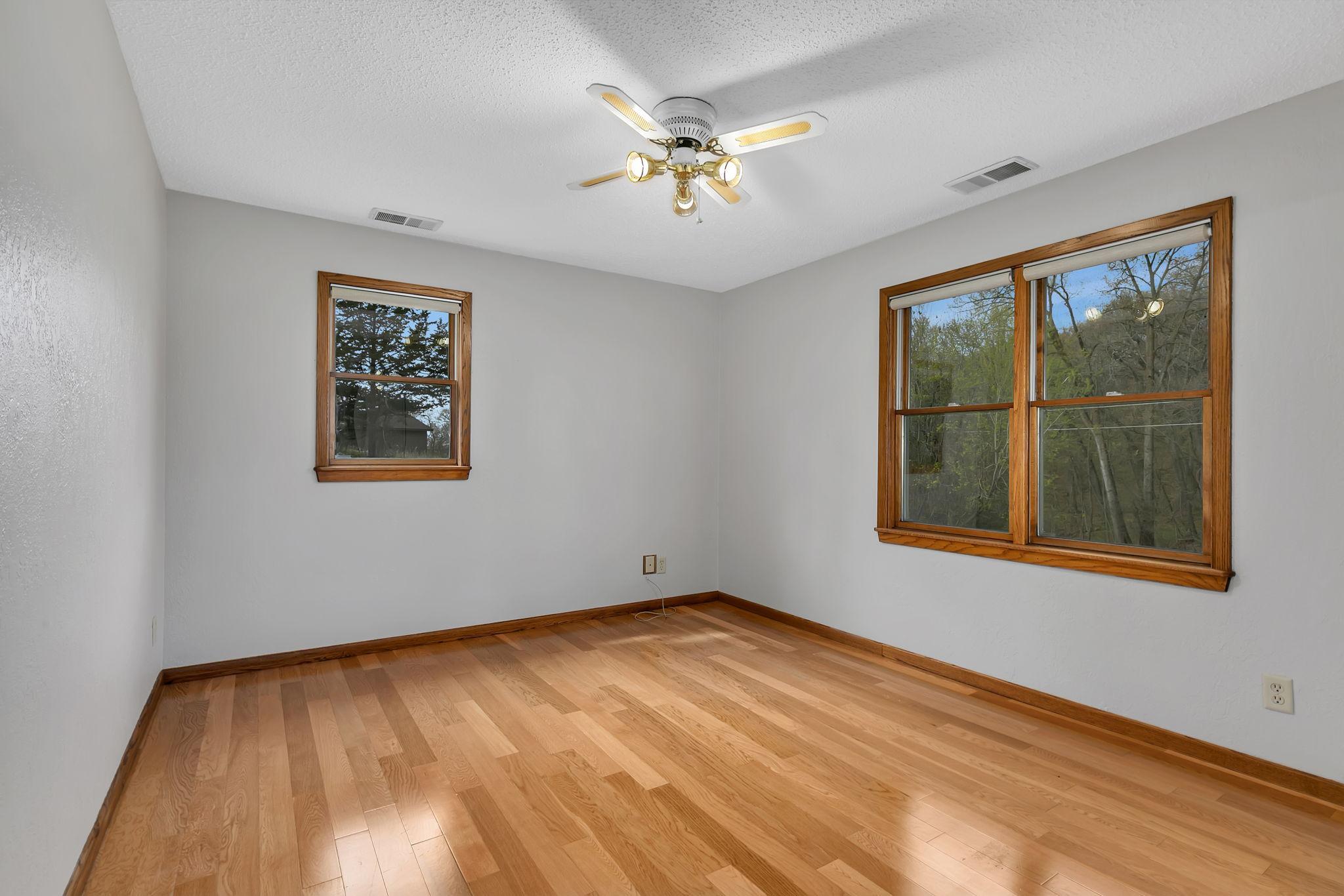 Large main level bedroom offers large windows, engineered hardwood floors along with a large closet and closet organizer. Freshly painted ceiling & walls throughout the home.