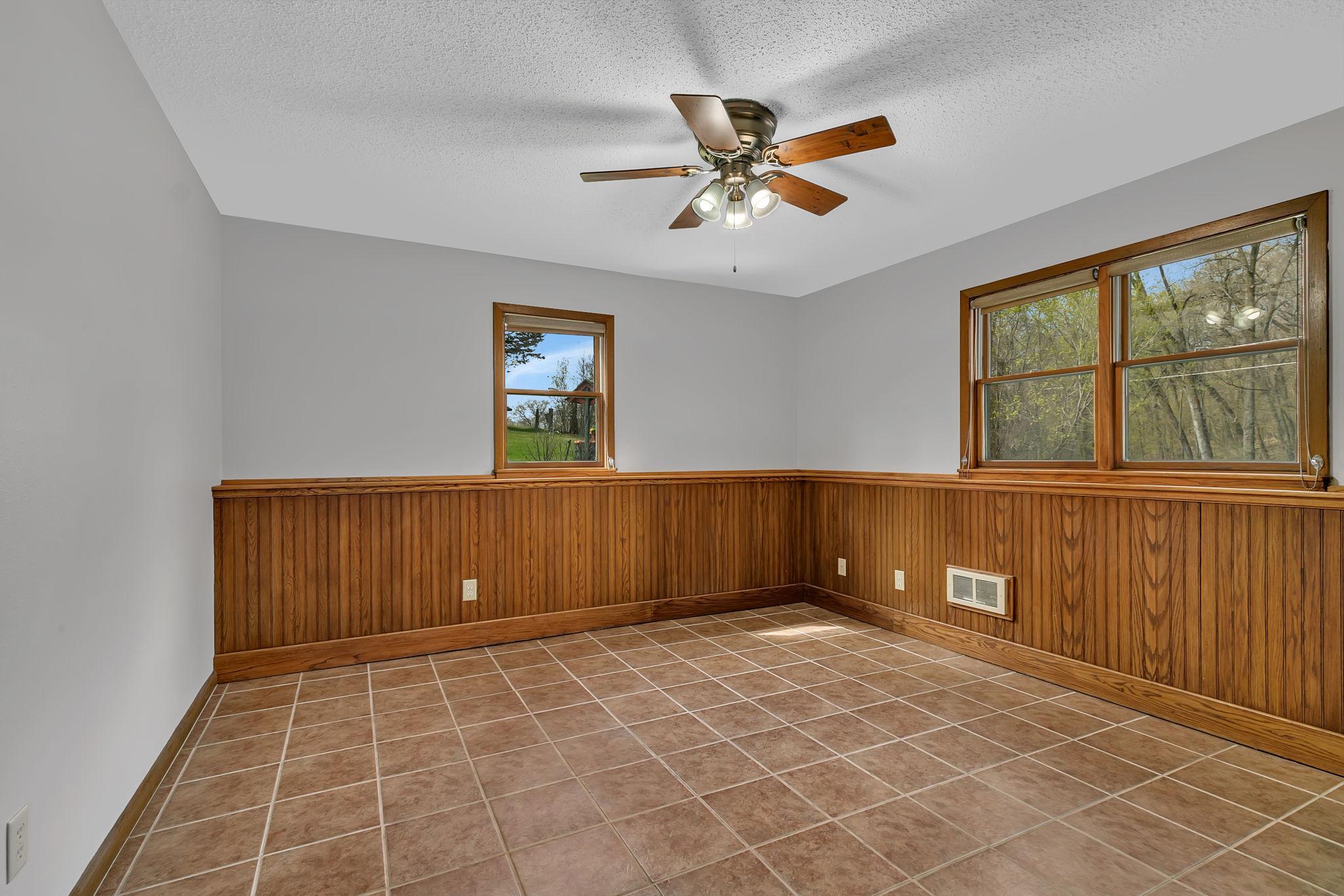 Basement bedroom with tile floor, wainscotting, and large closet with closet organizer. Move right in!