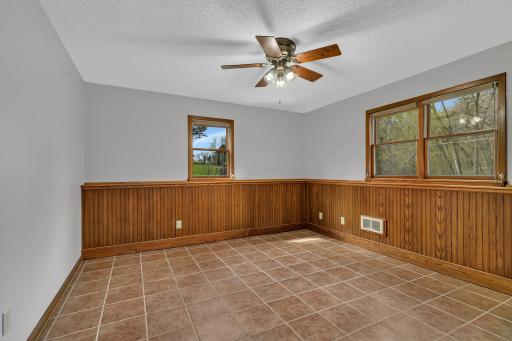 Basement bedroom with tile floor, wainscotting, and large closet with closet organizer. Move right in!