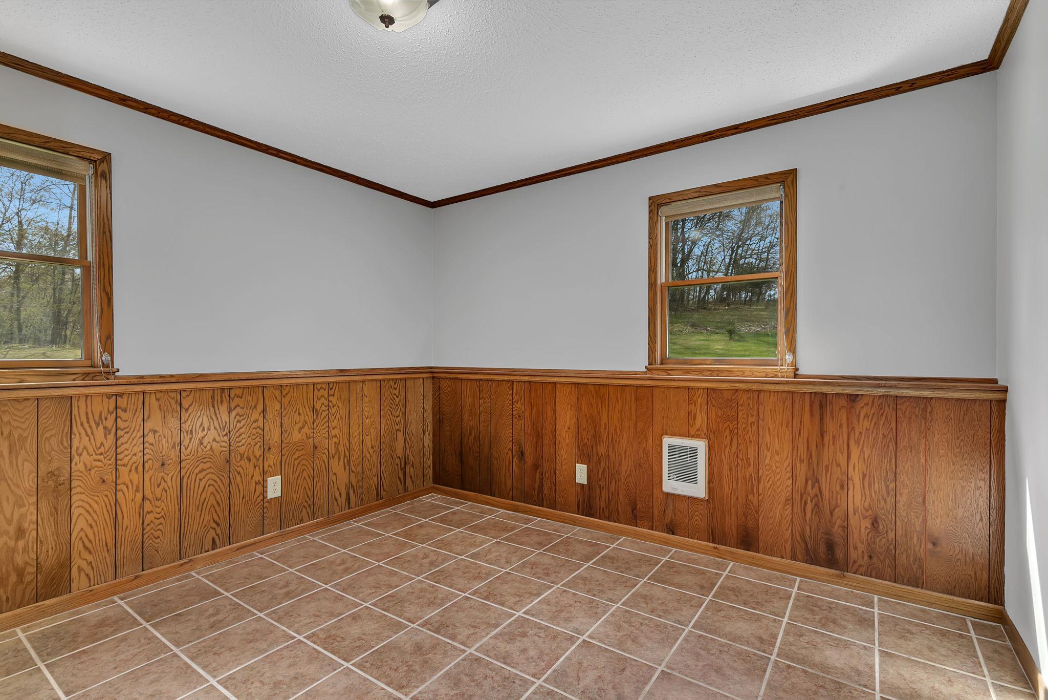 One of the lower level bedrooms offering tile floors, wainscotting, fresh ceiling & wall paint. Who's ready to make this home their own?