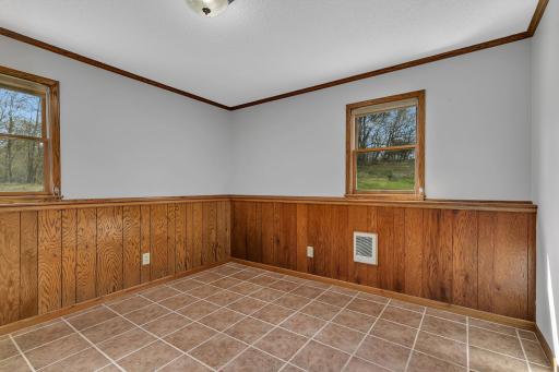One of the lower level bedrooms offering tile floors, wainscotting, fresh ceiling & wall paint. Who's ready to make this home their own?