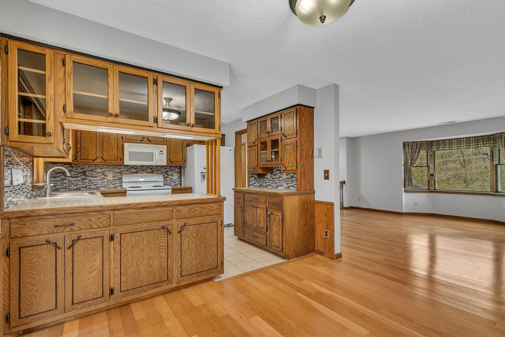 Dining area facing the kitchen & living room. Main level includes engineered hardwood flooring throughout. Large bay window offers natural light and some of the best summer breezes.