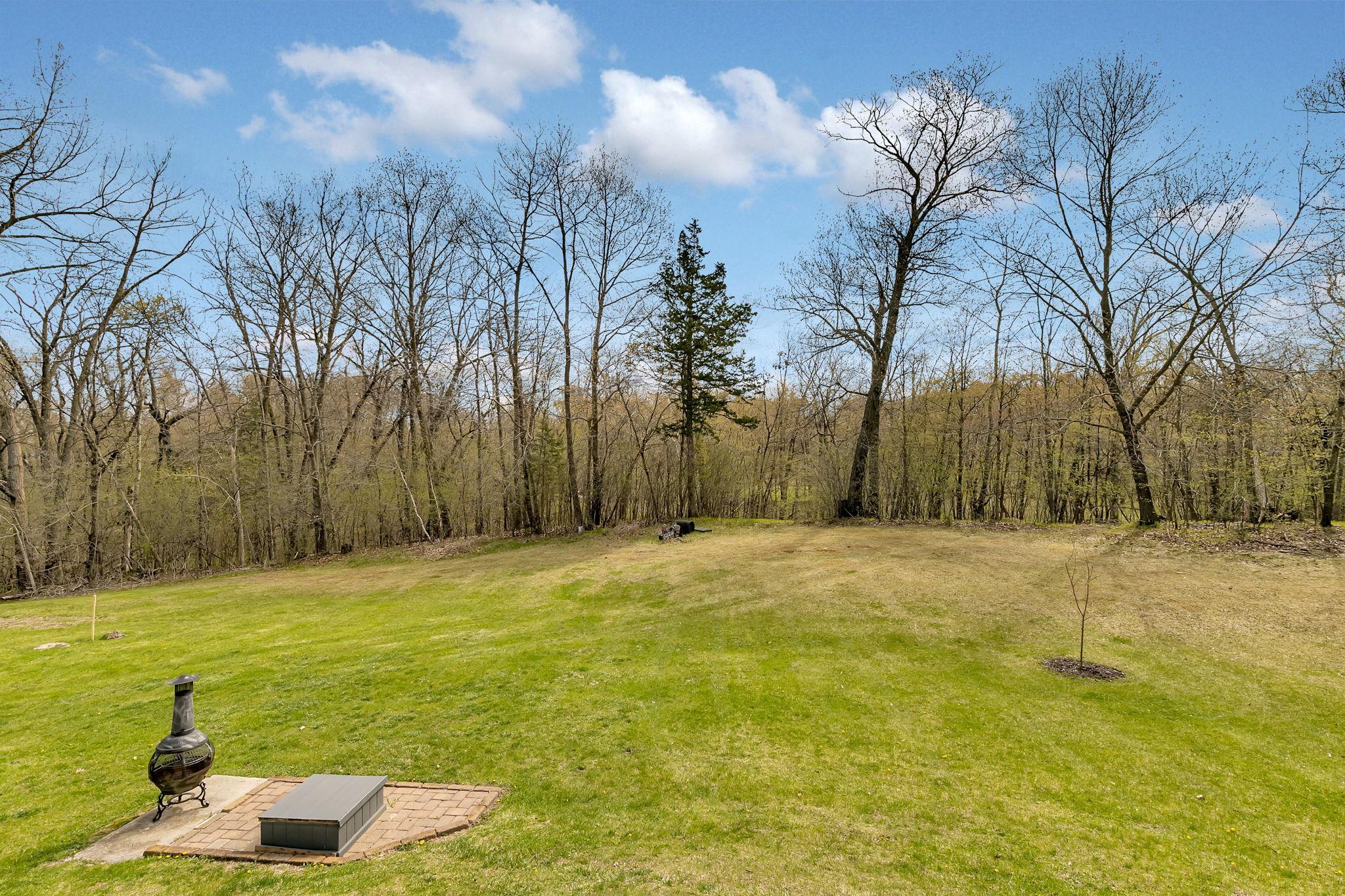 View towards the property line. The property line goes just into the tree line. Large open spaces.