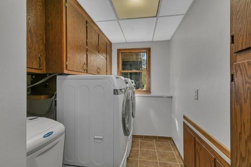 This laundry room offers a ton of cabinets for storage. It also includes the water heater & water softener.