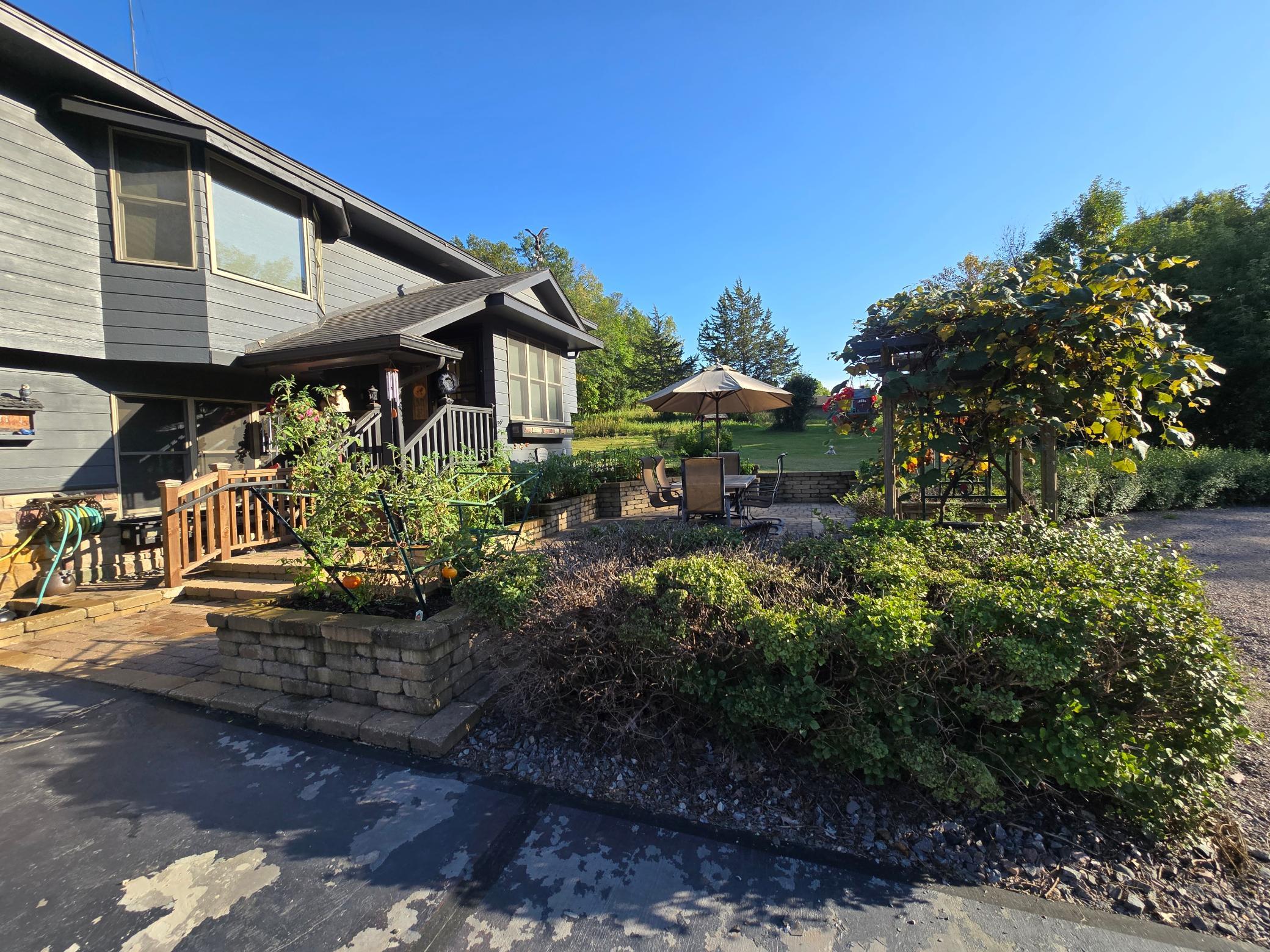 Large front paver patio is secluded by the dwarf lilac bushes.