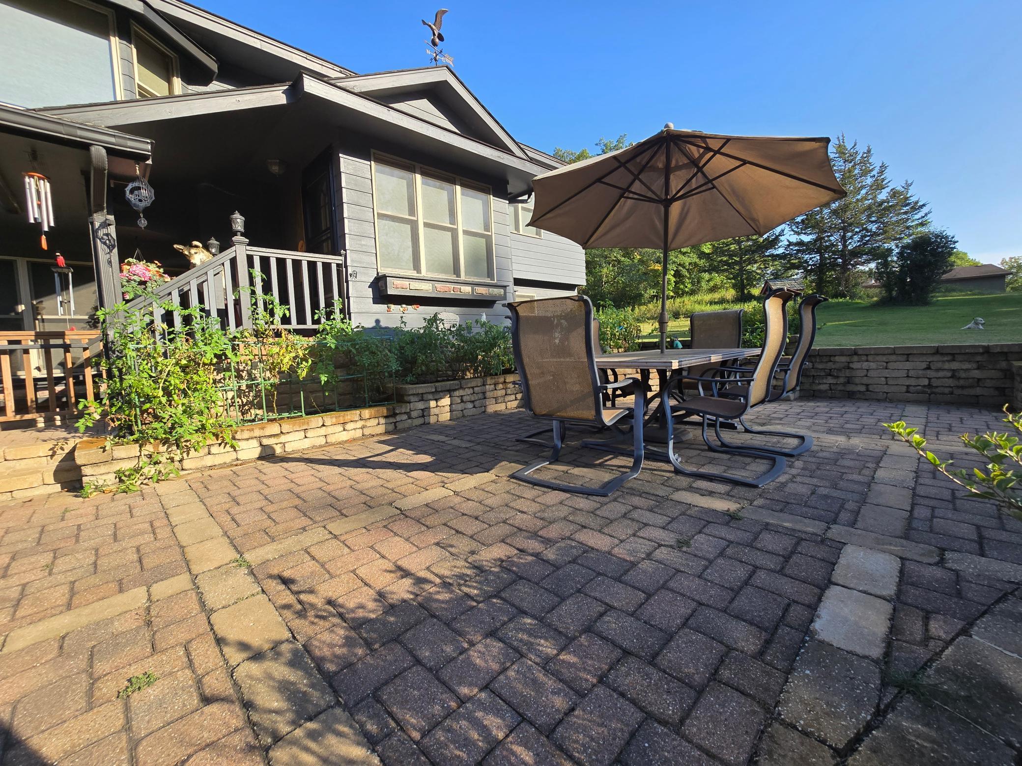 The front paver patio is an amazing space to spend time and enjoy some raised bed gardening. The hedges are lilacs and are simply amazing in the summer!
