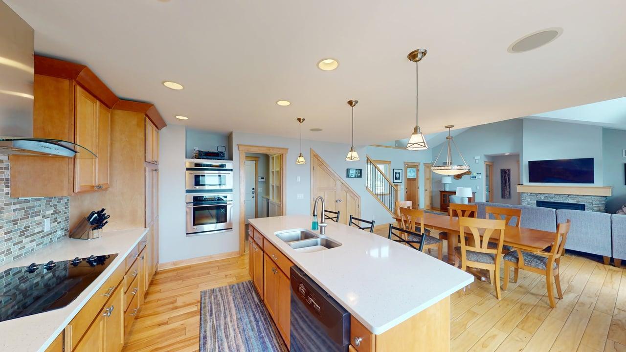 Additional kitchen view--cooktop, double ovens and views of the mud room with a built in nook and wine fridge.