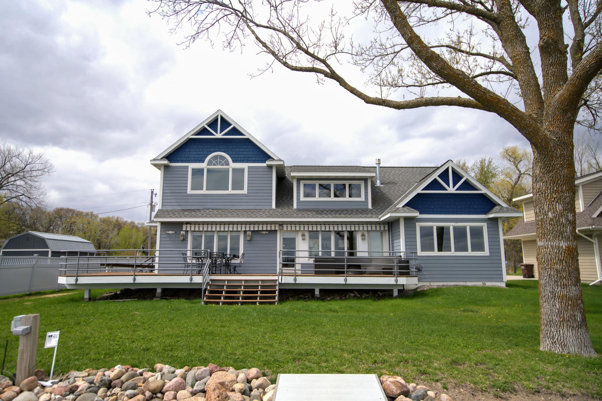 The large lakeside deck is perfect for gatherings, offering ample seating and easy access to the lake.
