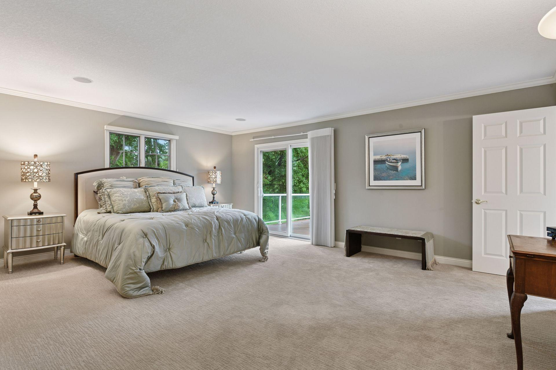 Main Level Primary Suite offers lake views from both the bedroom & bathroom and sliding glass door gives access to deck.