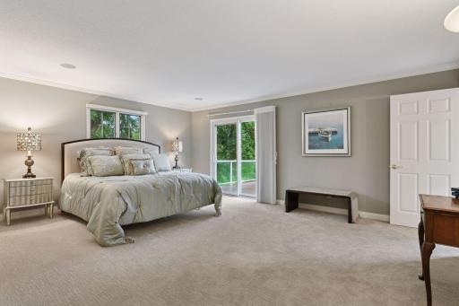 Main Level Primary Suite offers lake views from both the bedroom & bathroom and sliding glass door gives access to deck.