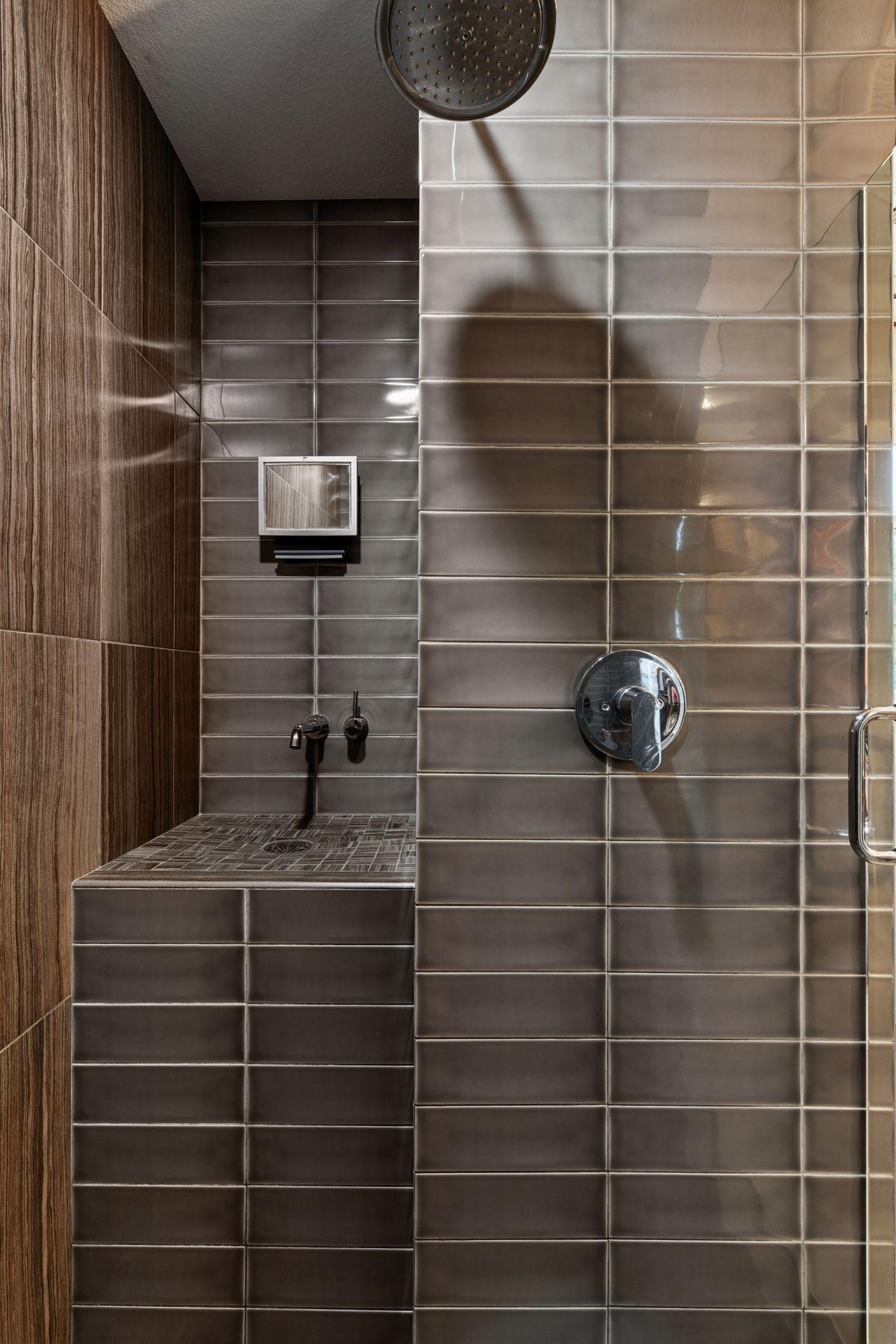 Step in shower with custom shaving niche with faucet.