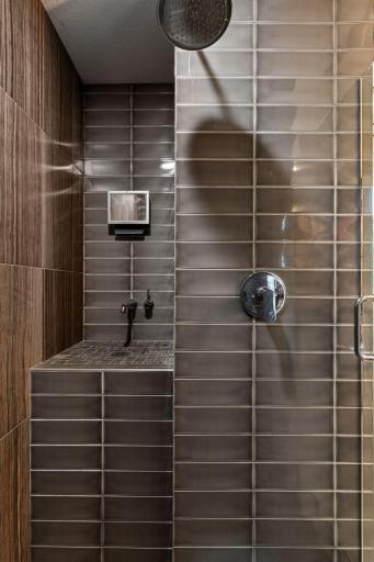 Step in shower with custom shaving niche with faucet.