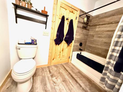 Full guest bath with tile floor and tile surround