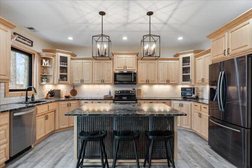 Custom staggered maple cabinets, tile back splash, under cabinet lighting, sleek black lighting