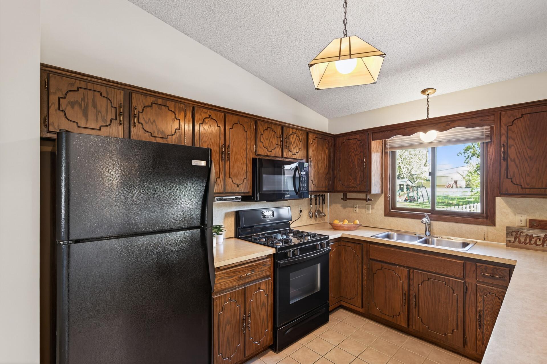 Immaculate kitchen with view of the big back yard as you prep.