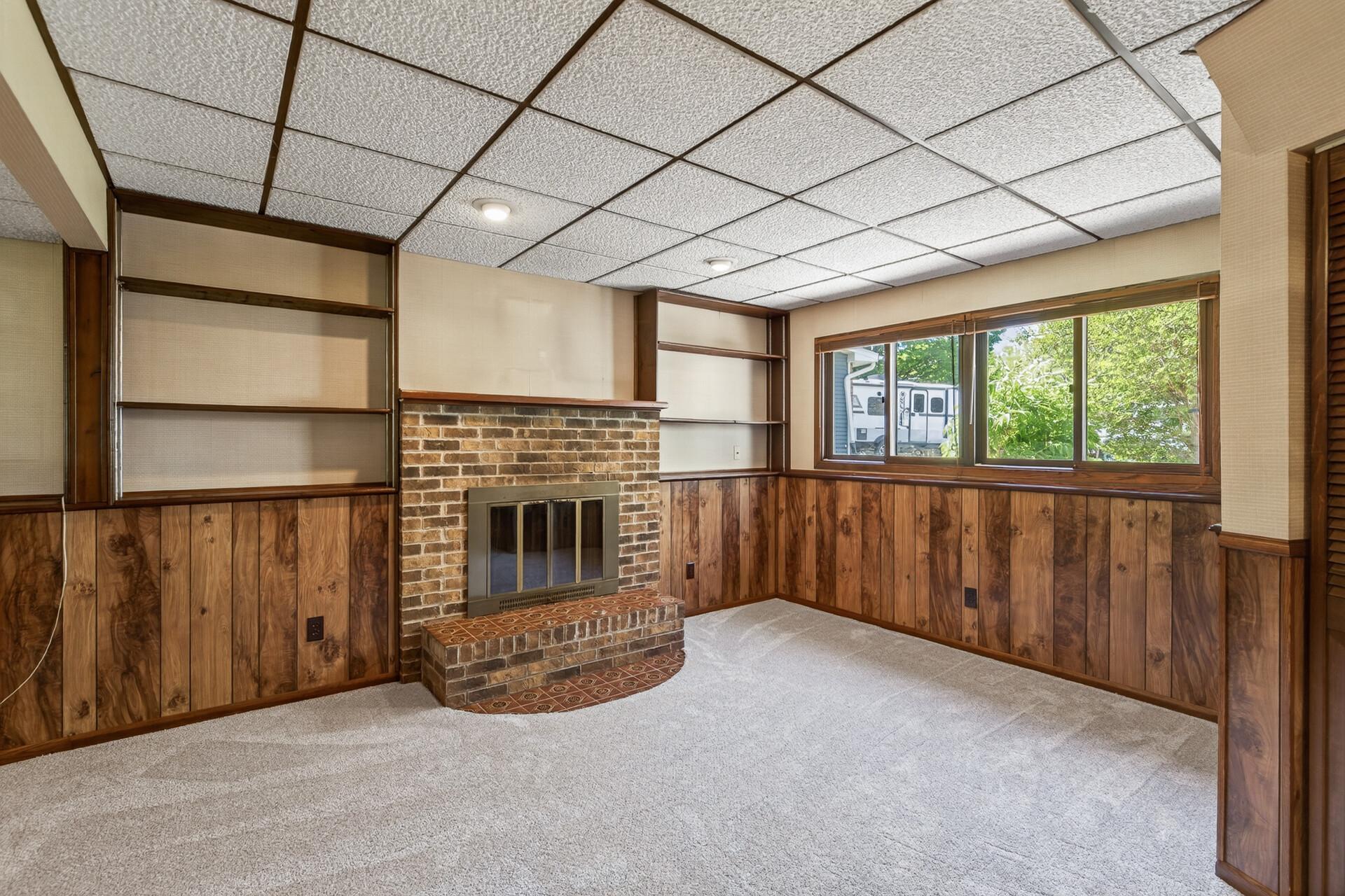 Wood burning fireplace and cozy lower level family room has wet bar entertaining area