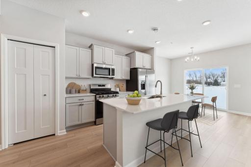 Kitchen features gray cabinets with brushed nickel hardware, white backsplash, with all GE appliances included - for illustrative purposes only