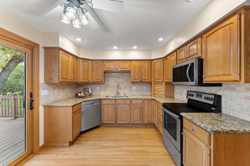 Remodeled kitchen that features oak cabinets, hardwood floors and quartz counters, plus tile backsplash!