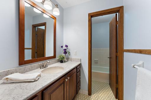 Main floor full bath with tile floors and separate space with tub/toilet
