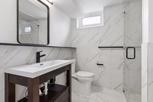 Walkout level renovated bathroom with heated floors and curbless entry walk-in shower.