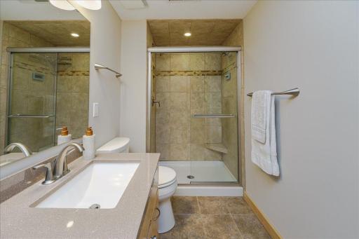 LL 3/4 Bathroom offers shower w/ tile surround and glass door as well as built-in linen cabinet.
