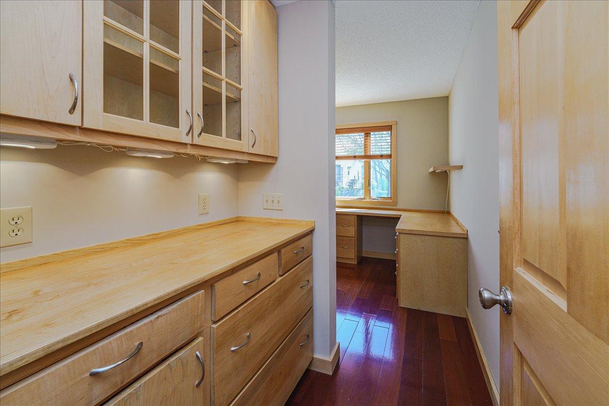 A custom home office w/ built-in cabinetry and workspace adds both function and style to the interior.