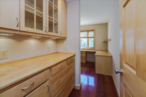 A custom home office w/ built-in maple cabinetry and dual workstations adds both function and style to the interior.