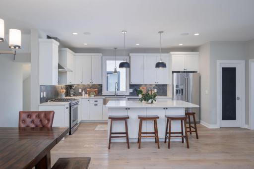 The gourmet kitchen is the heart of this home. White cabinetry, granite surfaces, stainless appliances, and a generous island with seating make it equal parts stunning and functional..